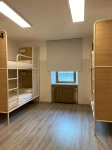 Cette chambre comprend 2 lits superposés et une fenêtre. dans l'établissement HostHello Nus, à Nus