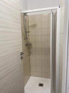 La salle de bains est pourvue d'une douche avec une porte en verre. dans l'établissement HostHello Nus, à Nus