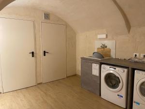 una lavanderia con lavatrice e asciugatrice di HostHello Nus a Nus
