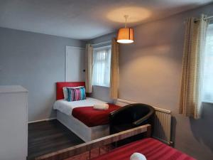 1 dormitorio pequeño con 1 cama y 1 silla en Poynters House - Huku Kwetu Luton & Dunstable - Spacious 2 Bedroom- Suitable & Affordable Group Accommodation - Business Travellers en Luton