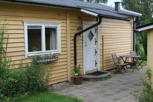una pequeña casa amarilla con una mesa y una puerta en Nyckelbo Vandrarhem, en Helsingborg