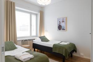 ein Krankenzimmer mit zwei Betten und einem Fenster in der Unterkunft Forenom Serviced Apartments Pori Antinkatu in Pori