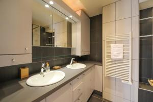 a bathroom with two sinks and a mirror at La Pause annécienne appartement familial in Annecy