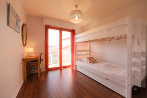 a bedroom with two bunk beds and a desk at La Pause annécienne appartement familial in Annecy