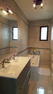 a bathroom with a sink and a tub and a mirror at Maison 4 pièces, 3 chambres avec Jardin et Terrasse in Lisses +4 photos