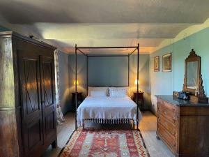 - une chambre avec un lit à baldaquin et une commode dans l'établissement La Verbia, à Sciolze
