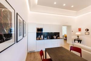 a kitchen and dining room with white cabinets and a table at La casa di Mimí in Vico Equense