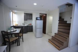 cocina y comedor con mesa y escalera en Homes by Gilmore Tower Suites, en Manila