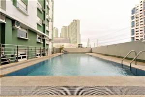 una piscina al lado de un edificio en Homes by Gilmore Tower Suites, en Manila