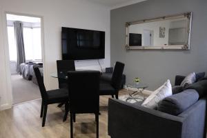 a living room with a couch and a table at EXECUTIVE APARTMENTS free on-site parking, 2 en-suites, sleeps 4, in Swindon