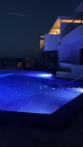 ein nachts beleuchteter Pool mit einem Gebäude in der Unterkunft Casa Paloma in San José