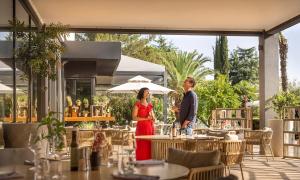 a man and woman standing under an umbrella in a restaurant at Aminess Vival Maestral Hotel in Novigrad Istria