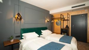LedineKAME HOTEL BELGRADE,贝尔格莱德凯美酒店的一间有两张床和一面绿墙的卧室