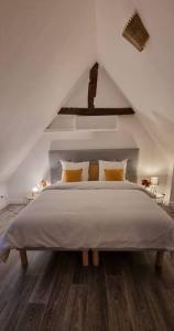 1 dormitorio blanco con 1 cama grande con almohadas amarillas en Grand Gîte - Le Saint-Chrirtophe, en Châteauroux