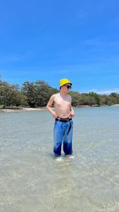 a man standing in the water on a beach at Beach Front Calatagan Apartelle in Calatagan