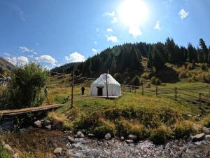 een yurt in het midden van een veld naast een rivier bij Mine Hostel Dzhergalan in Dzhergalan
