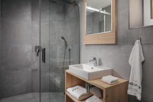 La salle de bains est pourvue d'un lavabo et d'une douche. dans l'établissement Ski & Spa hotel BELLEVUE, à Harrachov
