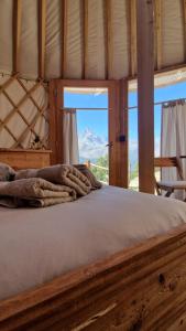 uma cama num quarto com vista para uma montanha em MonvisoRelax em Ostana