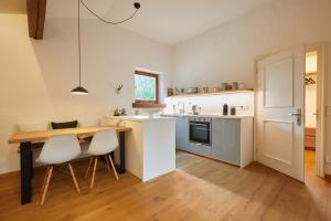 a kitchen with a wooden table and white appliances at Apartment Unterm Waxlstoa in Grainau