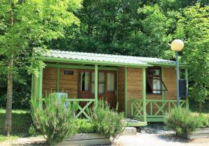 uma pequena cabana de madeira na floresta com árvores em CAMPING ETXARRI em Echarri-Aranaz