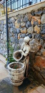a statue of a person sitting on a toilet next to a stone wall at İksir Villa in Fethiye