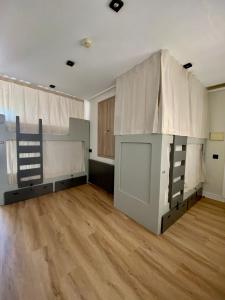 a room with two bunk beds and a wooden floor at La Banda Rooftop Hostel in Seville