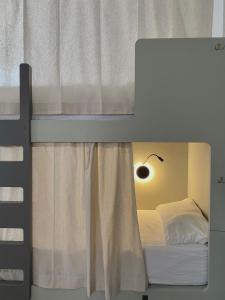 a bedroom with a bunk bed with a window at La Banda Rooftop Hostel in Seville