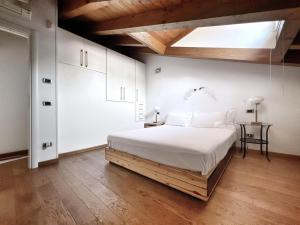 una camera con un grande letto bianco e un lucernario di UR NEST Ceneri a Bologna