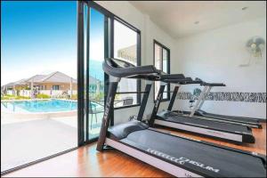 a treadmill in a gym with a view of a pool at Modern Villa Club House Hua Hin 18 私家SPA池独栋别墅 in Hua Hin