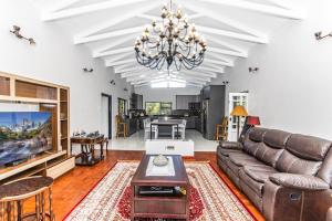 uma sala de estar com um sofá e uma televisão em KwaMagogo Villa, Chartwell em Joanesburgo