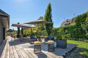 een patio met een tafel en stoelen en een parasol bij ALSACE Cosy in Schoenau