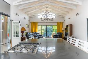 cocina y sala de estar con lámpara de araña en KwaMagogo Villa, Chartwell en Johannesburgo