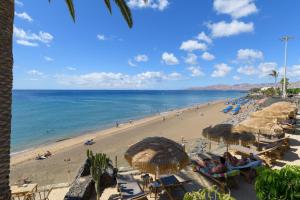 een strand met stoelen en parasols en de oceaan bij Casa Folias in Puerto del Carmen