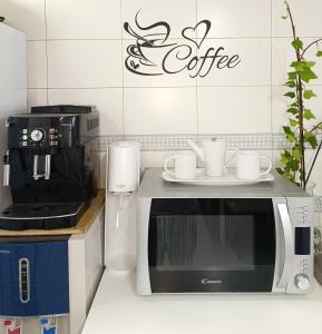 una cocina con microondas y tazas de café en una encimera en Casa de Mirtha, en Madrid