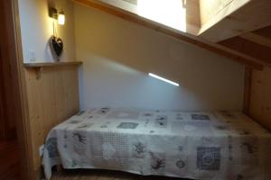 una piccola camera da letto con un letto con una coperta bianca di Appartement chaleureux, 8 personnes, 3 chambres - COEUR12 a Beaufort