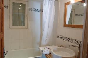 a bathroom with a tub and a sink and a mirror at Chalet centre village, 8 personnes, 4 chambres - CH25 in Beaufort