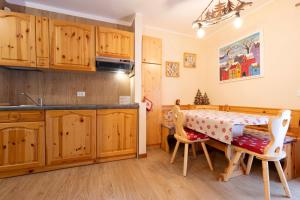 卡納澤伊的住宿－Cesa Ariale，厨房配有木制橱柜和桌椅