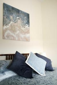 ein Bett mit schwarzen und weißen Kissen und einem Gemälde in der Unterkunft Drumnavaddy Cottage in Dromore