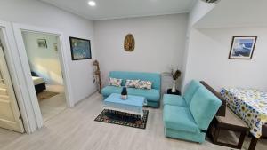 a living room with a blue couch and a bed at Condo Reina, Kusadasi in Kuşadası