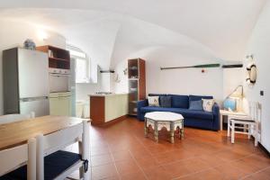 a living room with a blue couch and a kitchen at Beach Paradise- Luigi 16 in Levanto