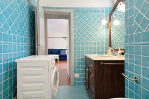 a blue tiled bathroom with a toilet and a sink at Beach Paradise- Luigi 16 in Levanto +16 photos