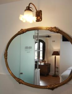 a large mirror with a light on a wall at Hotel Patria Chica in Priego de Córdoba