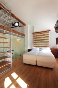 プリエゴ・デ・コルドバにあるホテル パトリア チカの白いベッド1台(木製ヘッドボード付)が備わるベッドルーム1室が備わります。