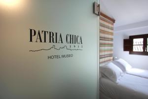 a bedroom with a bed and a sign on a wall at Hotel Patria Chica in Priego de Córdoba