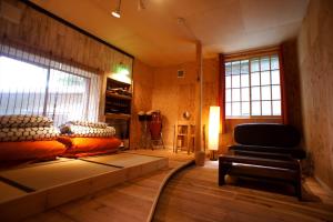 Habitación con cama y silla. en Saku Cafe en Daigo