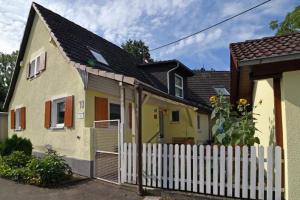 a yellow house with a white fence at Haus Elfriede in Müllheim