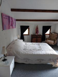 sypialnia z dużym łóżkiem i krzesłem w obiekcie La Quiétude w mieście Cotignac