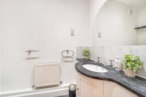 uma casa de banho com um lavatório e um radiador em Luxury 3 bedroom Flat Trafalgar Square, Embankment, Waterloo em Londres