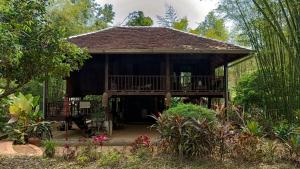 a pavilion with a deck in a garden at Traditional Lanna house near hot spring in Chiang Dao