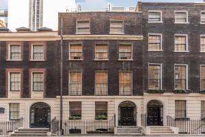 um grande edifício de tijolos com portas e janelas pretas em Luxury 3 bedroom Flat Trafalgar Square, Embankment, Waterloo em Londres